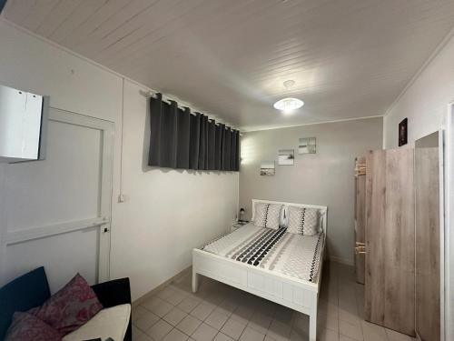 une chambre avec un lit blanc dans une pièce dans l'établissement Studio accueillant aux Trois-Îlets, 30 m², piscine partagée, à Lazaret