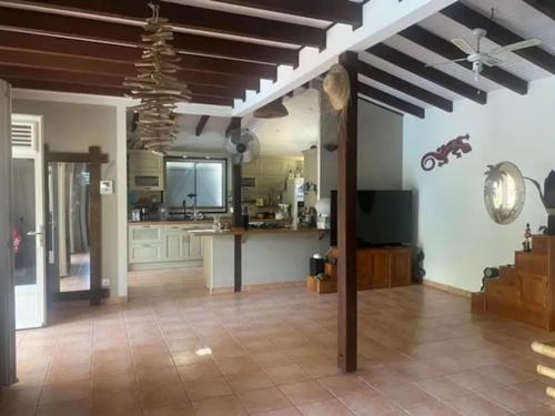 a large room with a kitchen with a ceiling at Villa confortable à Les Trois-Îlets avec piscine privée in Lazaret
