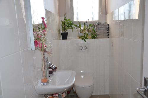 a bathroom with a sink and a toilet and plants at Chambre D'hôtes Et Spa in Agen