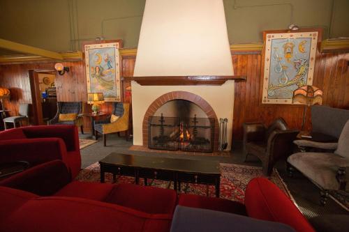 a living room with a fireplace and red furniture at McMenamins Anderson School in Bothell