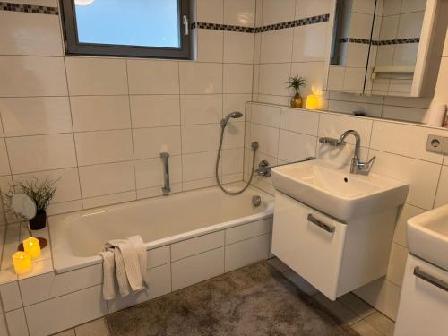 a white bathroom with a tub and a sink at Ruhe und Living in Unterraderach