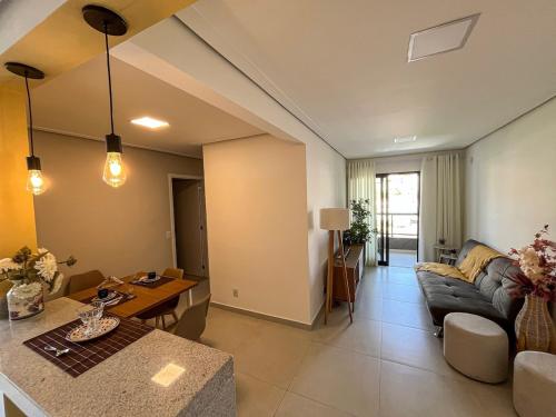 a living room with a couch and a table at RUA PLANA, 2qts, 2 banh, VARANDA c CHURRASQUEIRA, estacionamento, ELEVADOR, portaria in São Lourenço