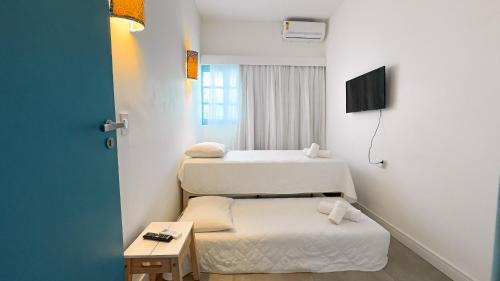 ein kleines Zimmer mit zwei Betten und einem Tisch in der Unterkunft Casa Azul Maragogi in Maragogi