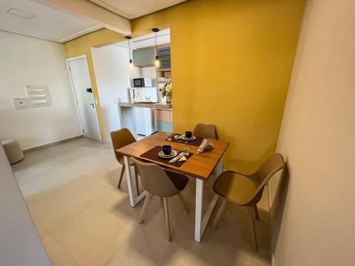 a dining room with a wooden table and chairs at RUA PLANA, 2qts, 2 banh, VARANDA c CHURRASQUEIRA, estacionamento, ELEVADOR, portaria in São Lourenço