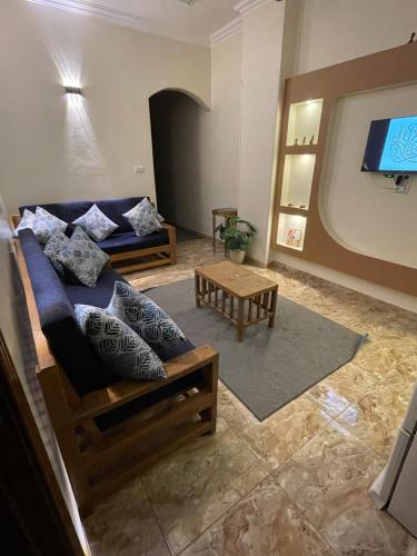 a living room with a couch and a tv at Luxe Nest Guest House Apartment 102 in Luxor