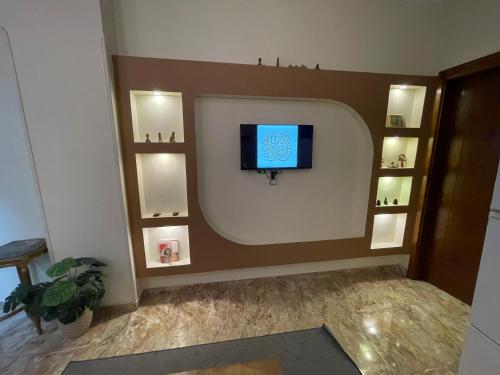 a living room with a tv on a wall at Luxe Nest Guest House Apartment 102 in Luxor