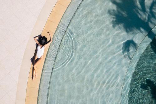 a person wearing a swimsuit and goggles next to a swimming pool at Nautilux Rethymno by Mage Hotels in Rethymno Town