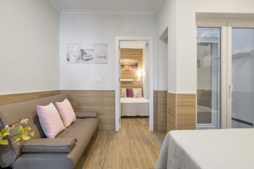 a living room with a couch and a bed at Apartamento Reyes Católicos Conil in Conil de la Frontera