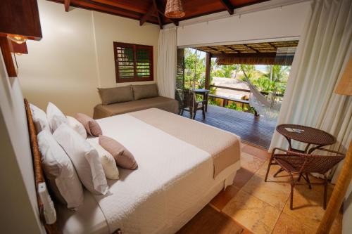 a bedroom with a bed and a balcony at Bangalô Kauli Seadi Eco-Resort in São Miguel do Gostoso