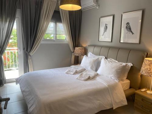 a bedroom with a large white bed with two pillows at Ninemia luxury apartments in Xylokastron