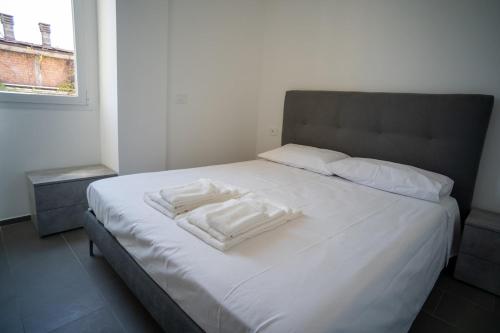 un letto bianco con due asciugamani bianchi di 15 Nevoso Palace a Milano