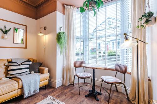 a bedroom with a table and chairs in front of a window at Rufloreo Flats 1 - central gem in Buxton