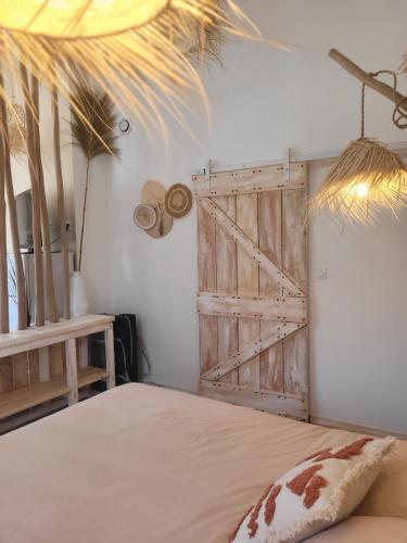a bedroom with a bed with a wooden door at Bel des Prés - Cocùn - Piscine partagée in Carquefou