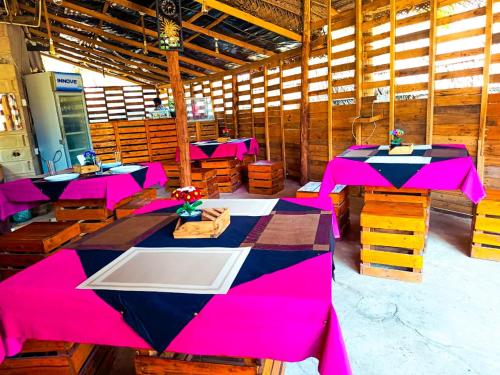 une salle avec des tables roses dans un bâtiment dans l'établissement Coco Cottage Kite Surfing-Kalpitiya, à Kandakuli