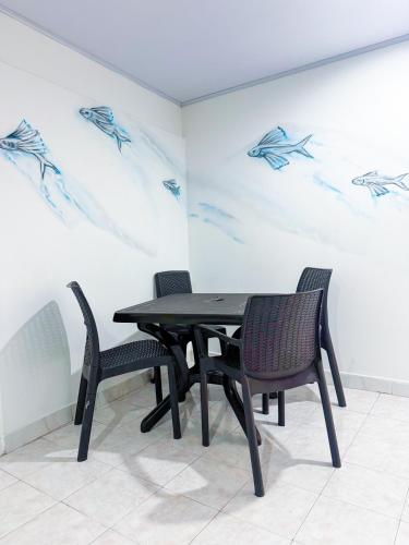 a black table and chairs in a room with a painting at Apartamentos Turísticos In Di Town in San Andrés