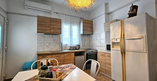 a kitchen with a stainless steel refrigerator and a table at Santorini Studios Pleasure in Perissa