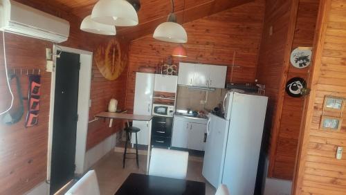 a kitchen with white appliances and wooden walls at El Cerrito del Valle in Santa María