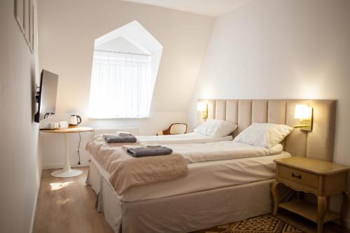 une chambre avec deux lits et une fenêtre dans l'établissement W Krainie Alicji, à Nałęczów