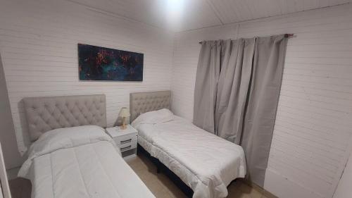 a bedroom with two beds and a window at El Cerrito del Valle in Santa María