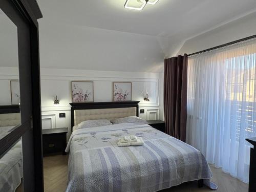 a bedroom with a bed with two shoes on it at Casa Pop in Petrova