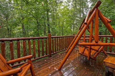 a wooden deck with a swing on top of it at In the Pines. Great location. Privacy in Hornet