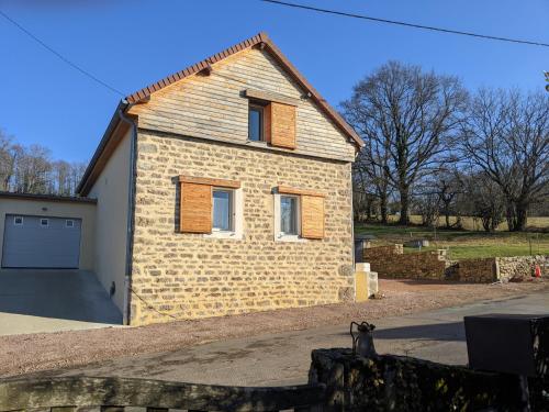 a brick house with a garage in a yard at L'échappée belle - Maison - Proche Le Creusot in Marmagne