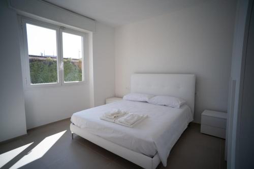 una camera da letto bianca con un letto bianco e una finestra di 16 Nevoso Palace a Milano