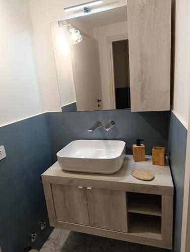 Un baño con un lavabo blanco y un espejo. en Altea, en Dervio