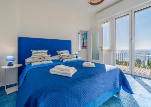 a bedroom with a blue bed with towels on it at La Casa sul Golfo - the House on the Gulf in Massa Lubrense