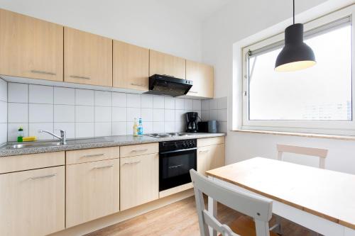 a kitchen with wooden cabinets and a table and a window at Boardinghouse St.Pauli in Hamburg