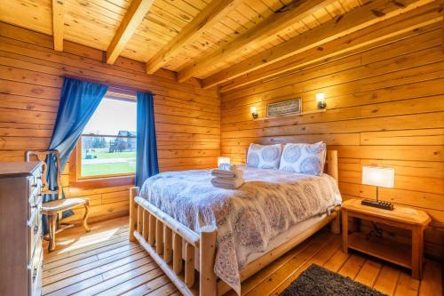 Un dormitorio con una cama en una cabaña de troncos en Rustic Cabin- Wineries and Breweries-Finger Lakes, en Teall Beach