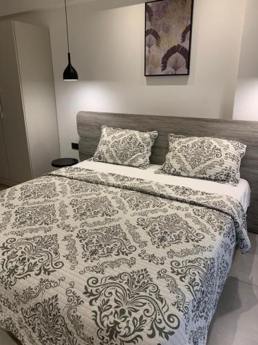 1 dormitorio con 1 cama con manta y almohadas en Amal Suites, en Accra