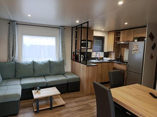 a living room with a couch and a kitchen at Superbe mobil-home à Seignosse plage in Seignosse