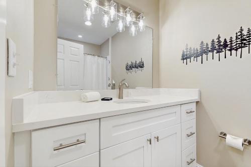 a white bathroom with a sink and a mirror at Hawk’s Landing at Innsbruck in Helen
