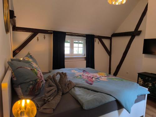 a bedroom with a bed with gloves and a lamp at Ferienhaus Heidefee in Wietzendorf
