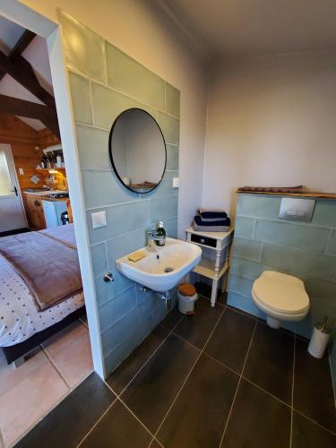 a bathroom with a sink and a toilet and a bed at Les Cabanes de Rouffignac in Rouffignac Saint-Cernin