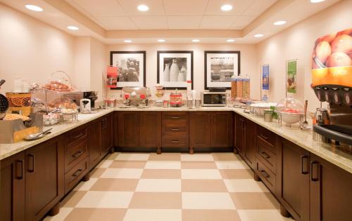 a large kitchen with wooden cabinets and a checkered floor at Wingate by Wyndham Cranberry in Cranberry Township