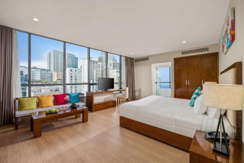 a hotel room with a bed and a large window at Avatar Danang Hotel in Da Nang
