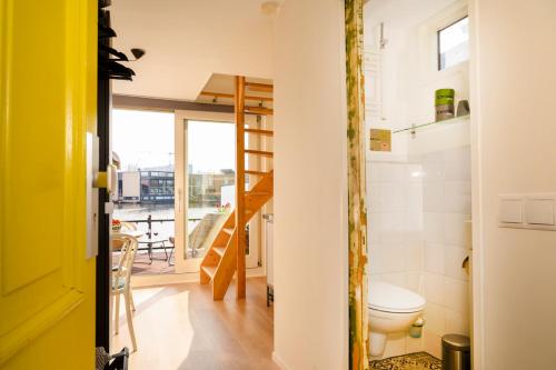 a small bathroom with a toilet and a balcony at Houseboat studio with canalview and free bikes in Amsterdam