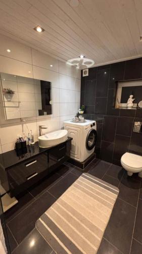 a bathroom with a sink and a washing machine at Guesthouse Near Nature & Shops in Kolding