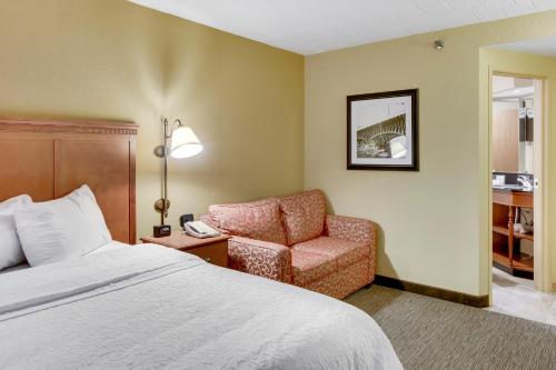 a hotel room with a bed and a chair at Wingate by Wyndham Cranberry in Cranberry Township