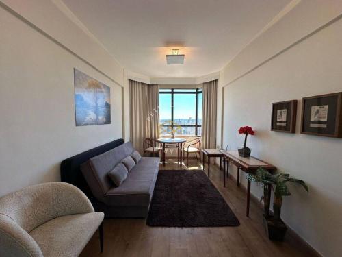a living room with a couch and a table at Lindo Apto Flat Aconchegante e Mobiliado em Campinas !!! in Campinas