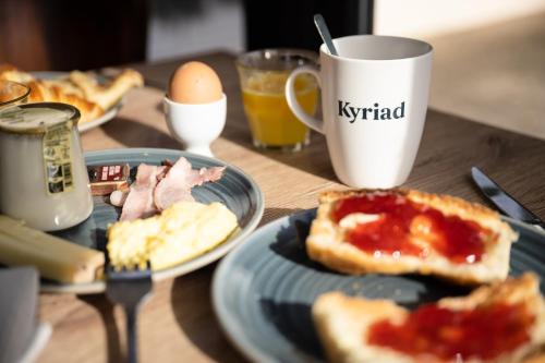 ボーヌにあるキリヤード ボーヌの朝食の皿とカップが置かれたテーブル