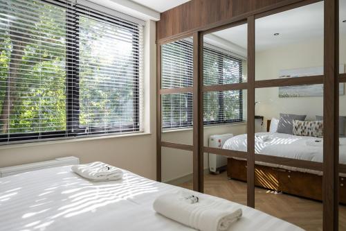 a bedroom with two beds and large windows at Luxury Flat Near Hove Station parking sleeps 4 in Moffat