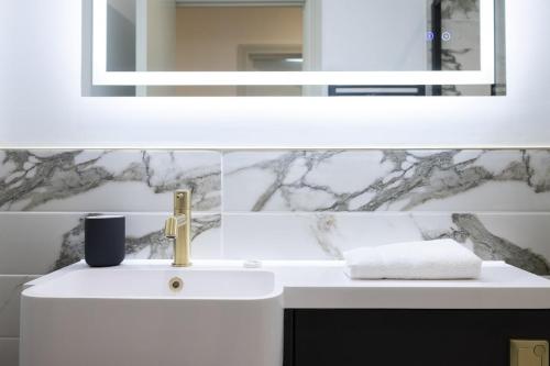 a bathroom with a white sink and a mirror at Luxury Flat Near Hove Station parking sleeps 4 in Moffat