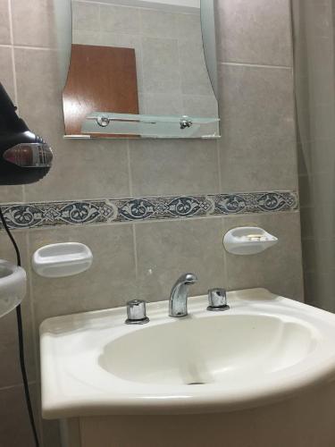 y baño con lavabo y espejo. en Apartamento Los Abuelos en Colón