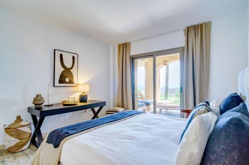 a bedroom with a bed and a desk with a window at Hacienda Senorio Cifuentes in Estepona