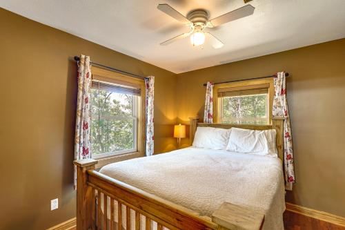 een slaapkamer met een bed, een plafondventilator en een raam bij Ozarks Waterfront Home with Dock and Marina Access in Warsaw