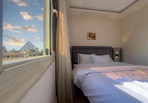 um quarto com uma cama e uma janela com vista em AKEN Pyramids View em Cairo