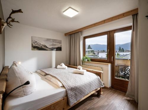 une chambre avec un lit et une grande fenêtre dans l'établissement Haus Adler by Alpine Host Helpers, à Westendorf